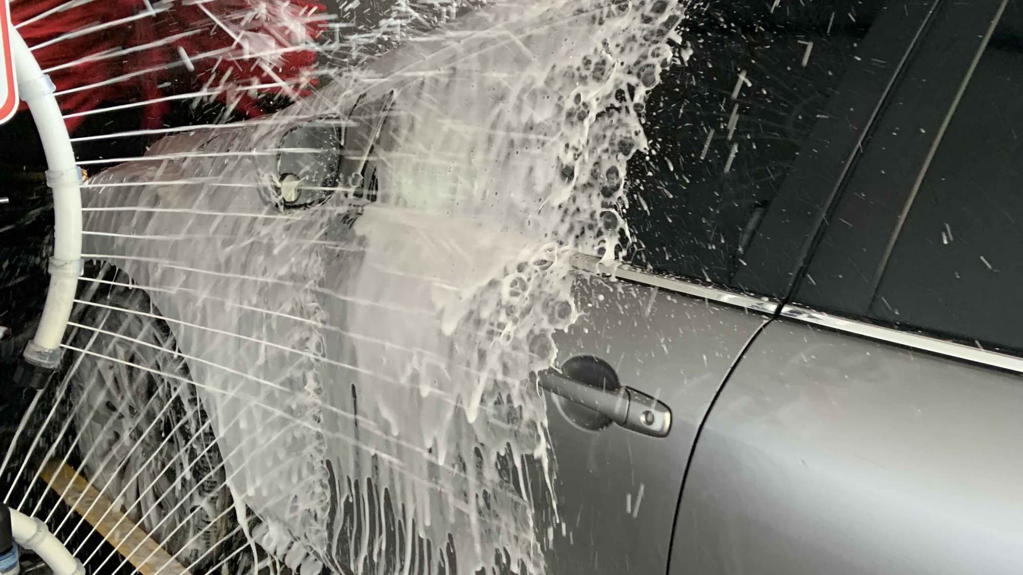 Thick cleaning foam sheeting down the side of a vehicle